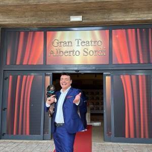 Igor Righetti con il suo inseparabile bassotto Byron davanti al Gran teatro che ha intitolato a suo cugino Alberto Sordi